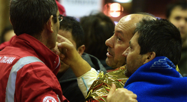 Un pasajero rescatado es protegido del frío por personales de la cruz roja italiana / Foto: Filippo Monteforte - AFP