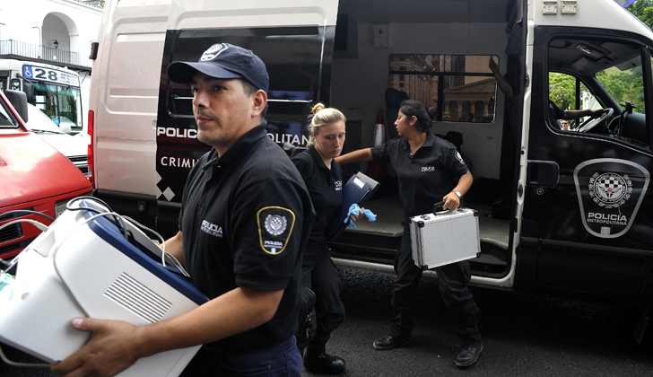 Oficiales de la policía metropolitana descargan documentos incautados en la residencia del fiscal Nisman, que hoy se hicieron públicos.