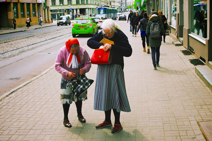 Escena de vida cotidiana en las calles de Riga, dos amigas buscando algo en sus carteras / Foto: Vadim Timoshkin 