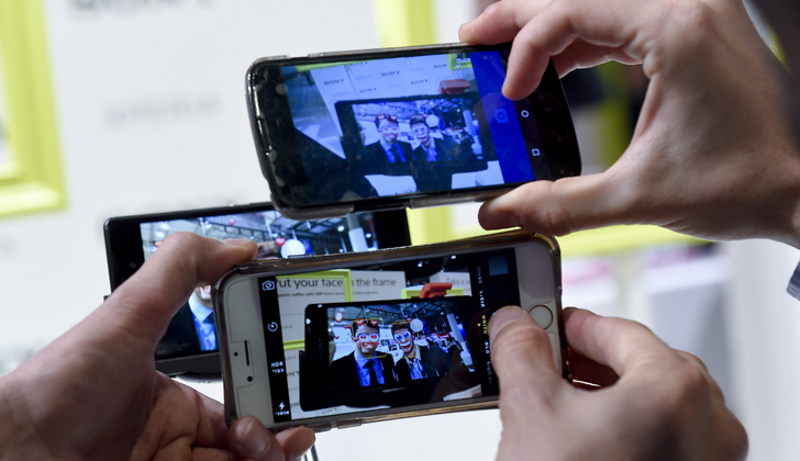 Visitantes del MWV2015 fotografían uno de los últimos modelos de teléfonos lanzados en esta conferencia. / Foto: Josep Lago - AFP