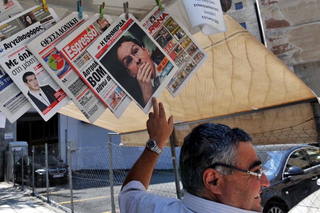 Un vendedor de periódicos muestras las portadas de este lunes en los principales diarios de Grecia, en la ciudad de Thessaloniki. Foto: Sakis Mitrolidis - AFP.