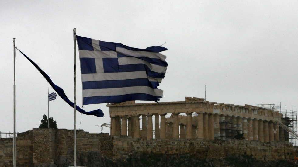 The flags of Greece, right, and European flag in tatters as they flutter from the roof of the Finance Minister at Athens' main Syntagma square, as in the background is seen the ancient Parthenon temple during a 24-hour strike on Tuesday, Feb. 7, 2012.