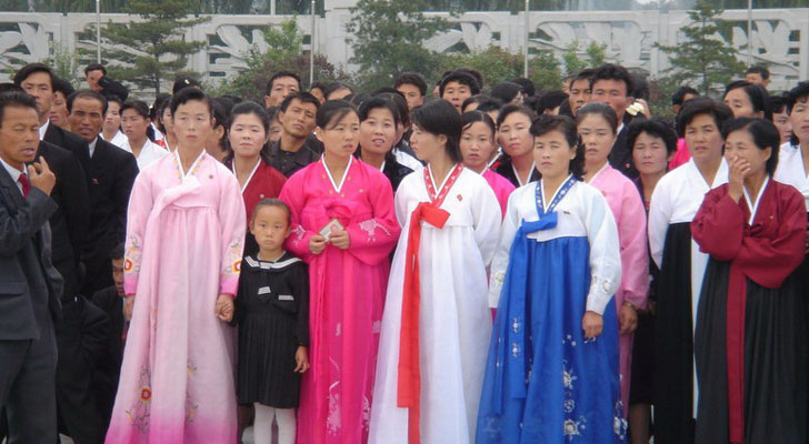 Jóvenes visten trajes tradicionales de Corea del Norte, junto a un grupo de oficiales militares. Foto: korea-dpr.com. 