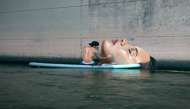 Artista pinta increíbles murales sobre el nivel del mar utilizando su tabla de surf.