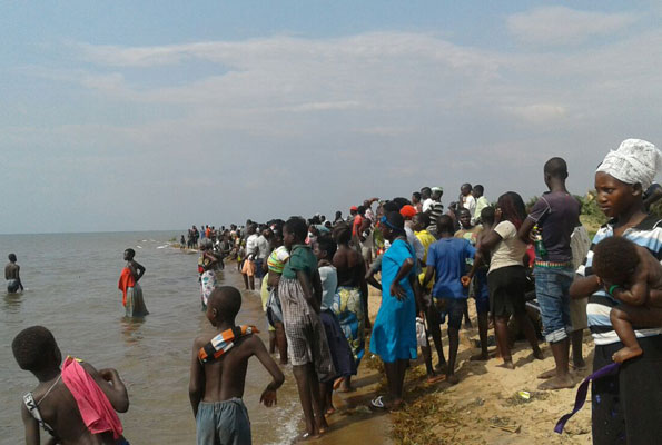 Personas observan el rescate de los náufragos del equipo de fútbol Buliisa, en Uganda. Foto: monitor.co.ug.