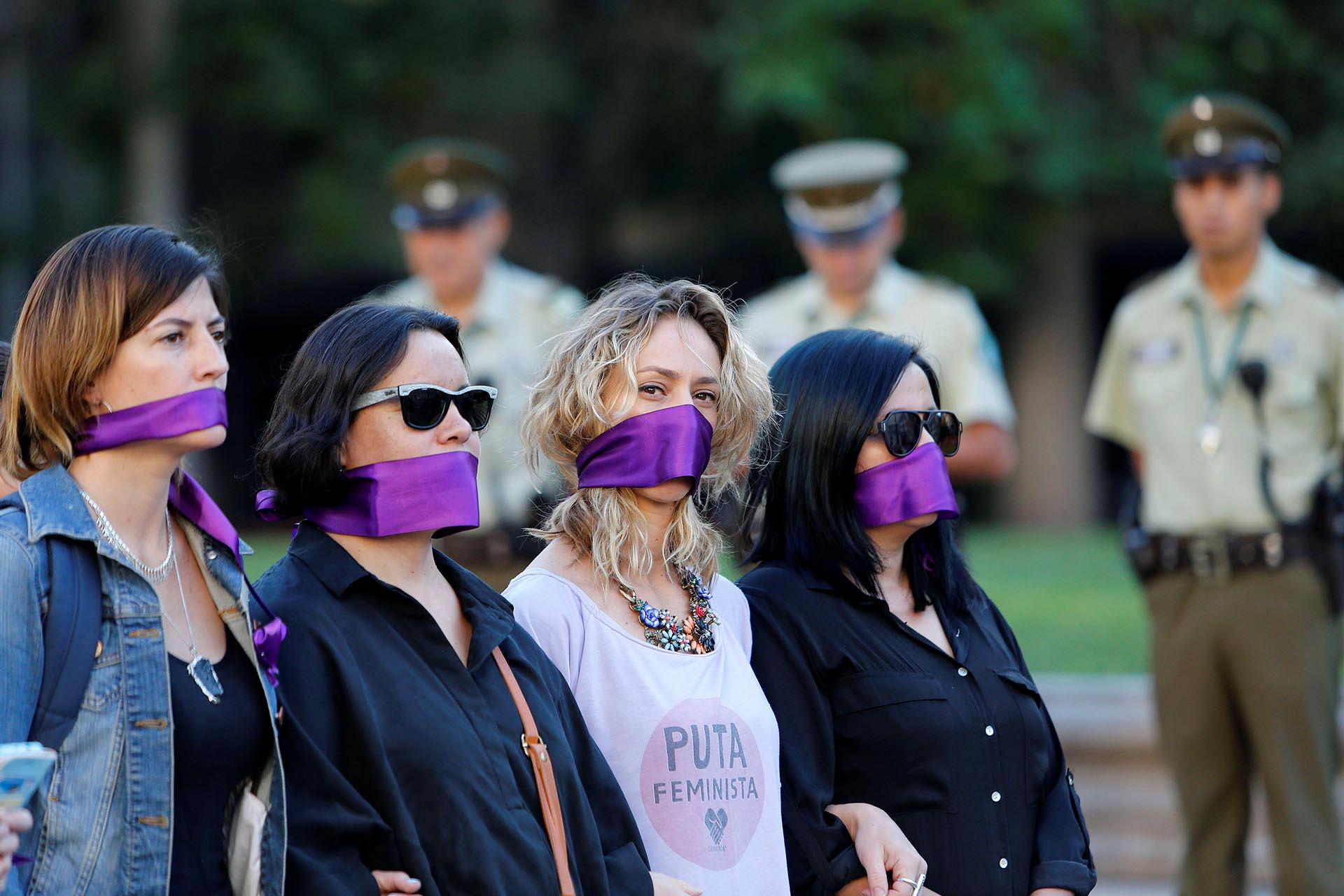Women cover their mouths as they attend a peaceful demonstration in front of the government house as part of International Women's Day, in Santiago, Chile March 8, 2017. REUTERS/Carlos Vera EDITORIAL USE ONLY. NO RESALES. NO ARCHIVE