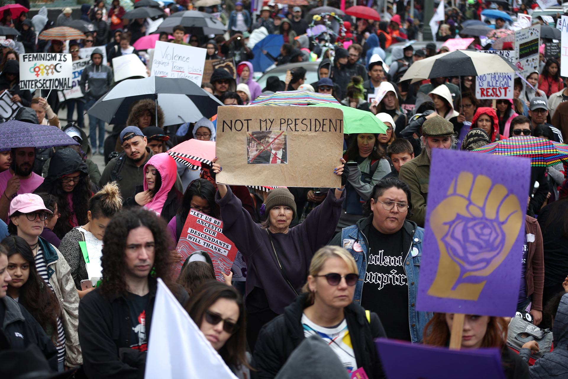 People listen to speakers in the rain at a rally for International Women's Day in Los Angeles, California, U.S., March 5, 2017. REUTERS/Lucy Nicholson