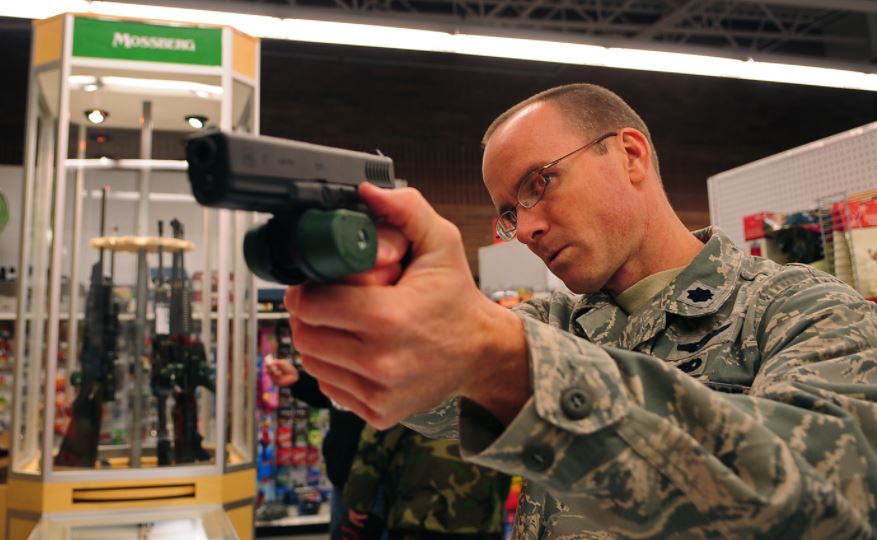 Un militar prueba una pistola en una tienda de armas. Foto: defense.gov