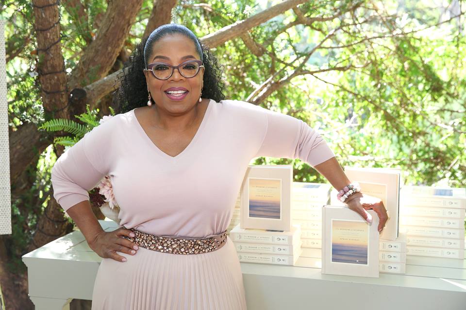 Oprah Winfrey posa frente a copias de su libro "La sabiduría de los domingos". Foto: Facebook Oprah Winfrey