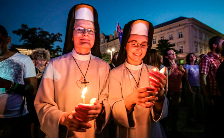 Dos peregrinas sostienen velas en el día Mundial de la Juventud en Krakow, Polonia / Foto: Beata Zawrzel/Pacific Press/Barcroft Images