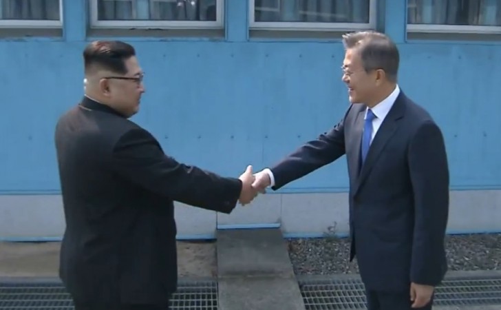 Kim Jong-un (izq) y Moon Jae-in se dan la mano en la línea que divide a las dos Coreas. Foto: YTN / Televisión estatal norcoreana