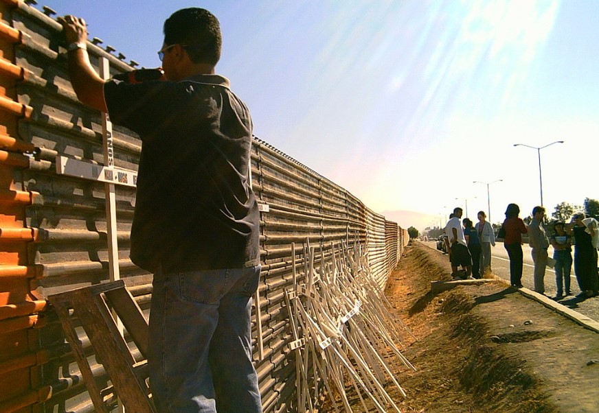 Un hombre clava una cruz en memoria de un muerto, en uno de los tramos del muro fronterizo entre Estados Unidos y México. Foto: Flickr/PiesCansados