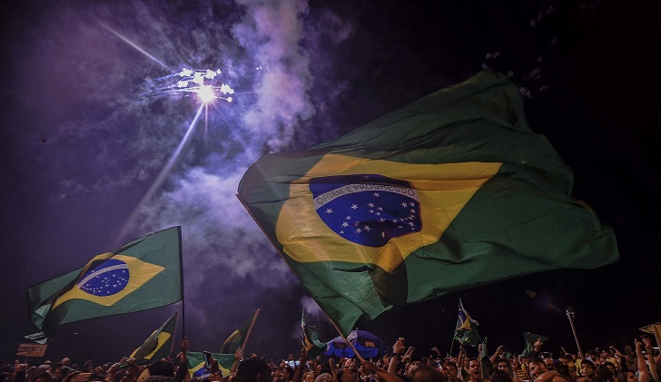 Supporters of far-right lawmaker and presidential candidate for the Social Liberal Party (PSL), Jair Bolsonaro, celebrate in Rio de Janeiro, after the former army captain won Brazil's presidential election, according to official results that gave him 55.7 percent of the vote, on October 28, 2018. - Far-right former army captain Jair Bolsonaro won Brazil's presidential election Sunday, according to official results that gave him 55.7 percent of the vote with more than 88 percent of the ballots counted. (Photo by Carl DE SOUZA / AFP)