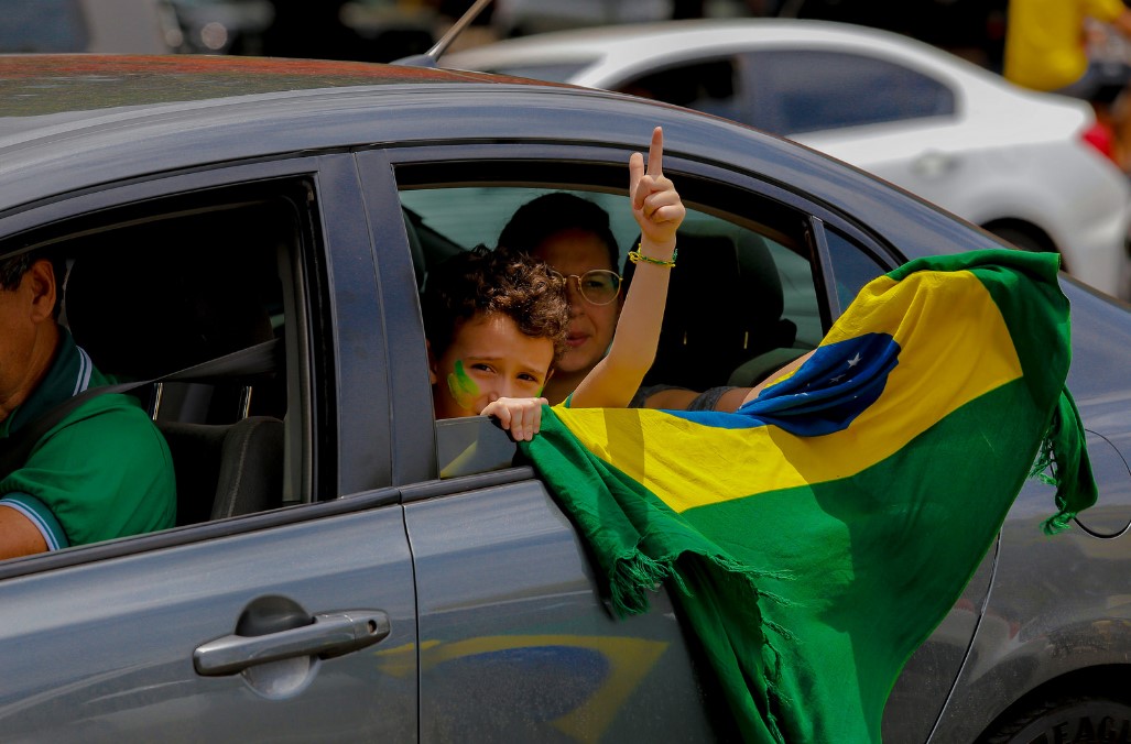 Un niño en Brasilia hace un gesto con la mano simbolizando una pistola que dispara. Este fue el saludo de campaña de Jair Bolsonaro. Foto: Flickr / Alessandro Dias