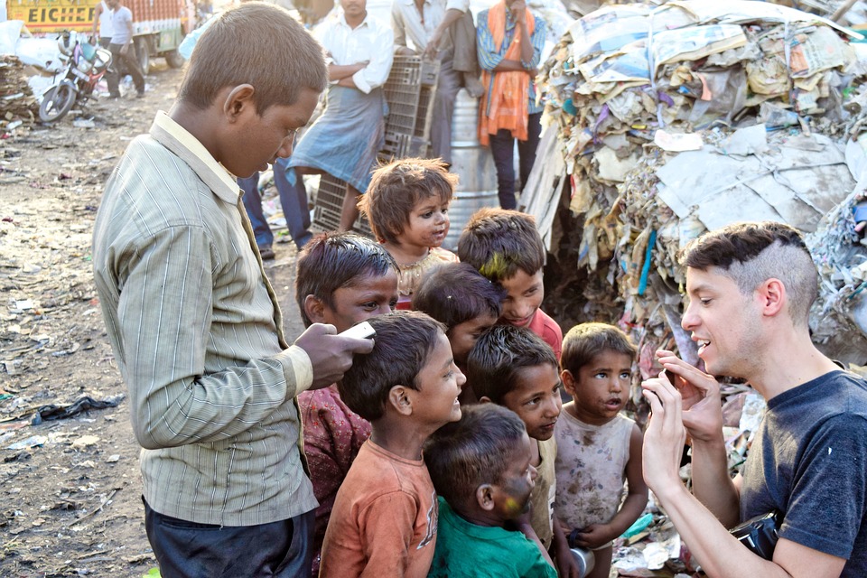 Un voluntario de una ONG toma fotos de un grupo de niños en un tugurio de la India. Foto: Pixabay