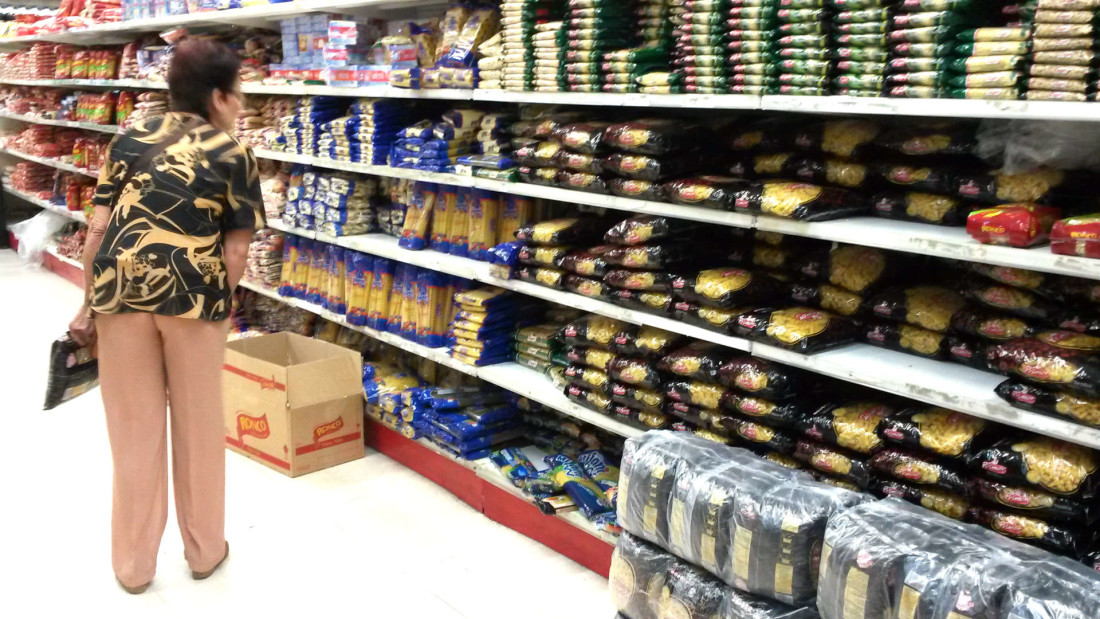 Una mujer observa los precios de alimentos básicos en un supermercado de Caracas. Foto: cortesía de VPI
