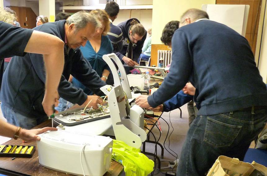 Varias personas reparan electrodomésticos en el "Repair Cafe", en Reading, Reino Unido. Foto: Wikimedia Commons 