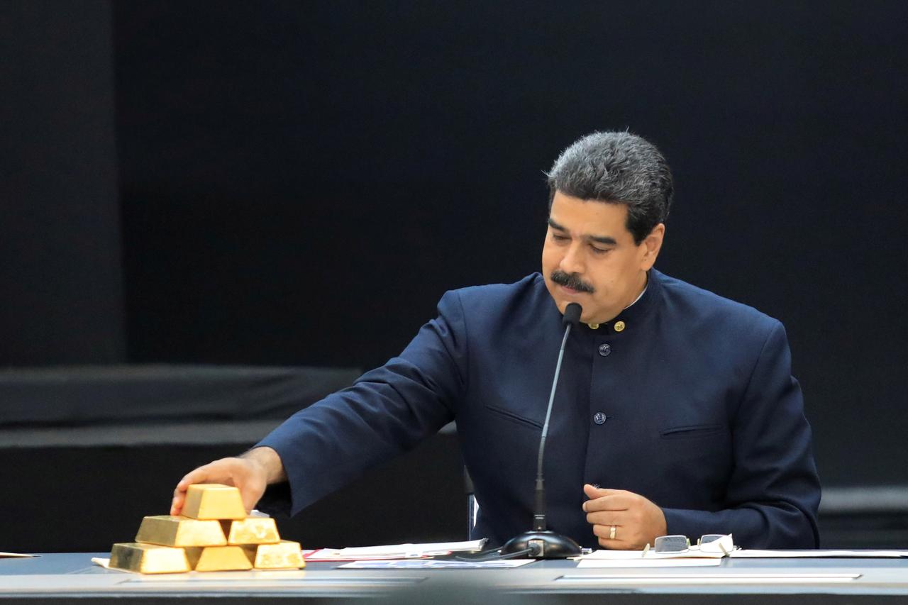 Nicolás Maduro toca unos lingotes de oro, en una reunión con ministros del área económica, en el Palacio de Miraflores (Caracas), en marzo de 2018. Foto: REUTERS/Marco Bello 