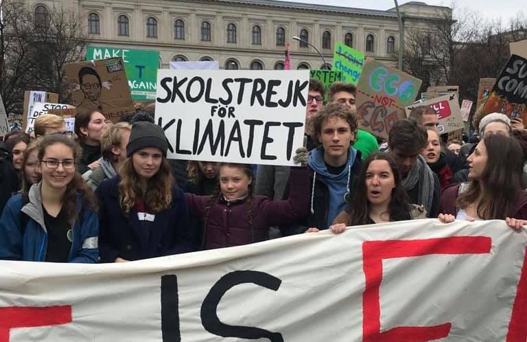Greta Thumberg sostiene un cartel que reza "huelga estudiantil por el clima"