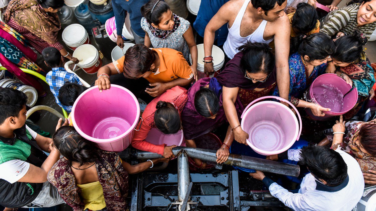 Decenas de personas hacen fila para acceder a un poco de agua potable. Foto: Saumya Khandelwal / MIT Technology Review