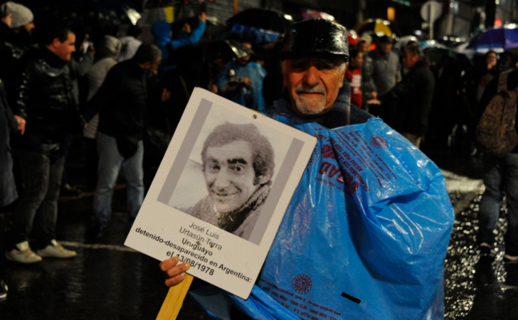 Hombre bajo la lluvia reclama por un desaparecido / Foto: Presidencia