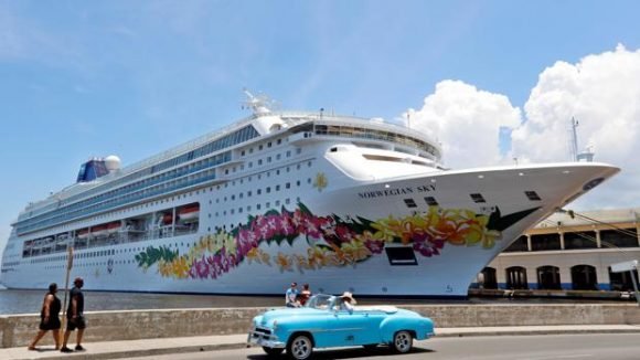 Un auto clásico pasa frente a un crucero que venía de Estados Unidos. Foto: Agencia Cubana de Noticias - Cubadebate