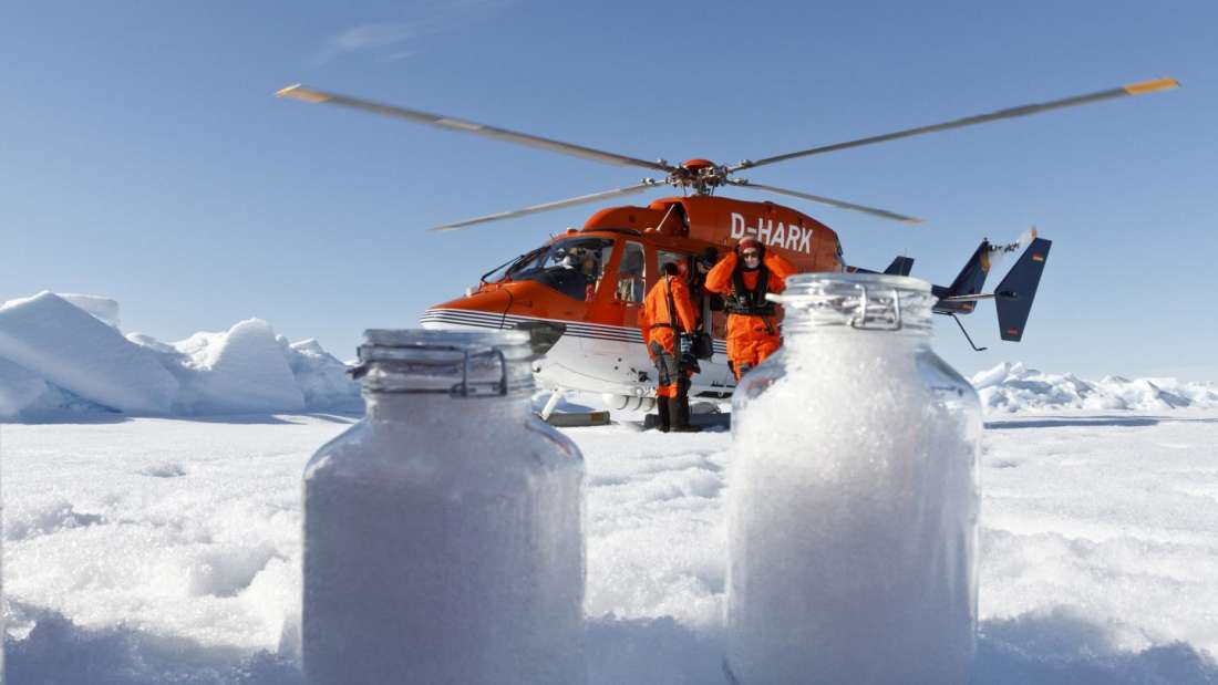 Científicos del Instituto Alfred Wagener en un helicóptero en el Ártico. Recopilan muestras de nieve para revisar la presencia de microplásticos
