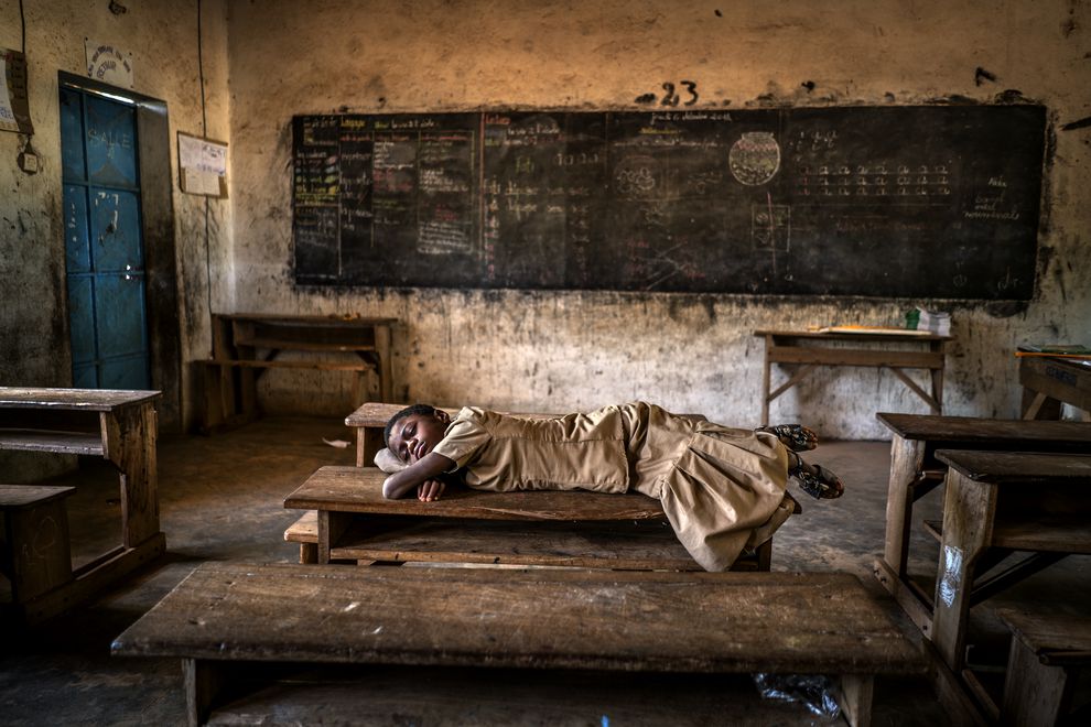 Una niña duerme en un pupitre de su escuela en Sahel, al sur del desierto del Sahara. En los últimos 35 años las lluvias extremas se han multiplicado debido al calentamiento global provocando inundaciones todos los años, seguidas de episodios de sequía. Foto: Antonio Aragon Renuncio