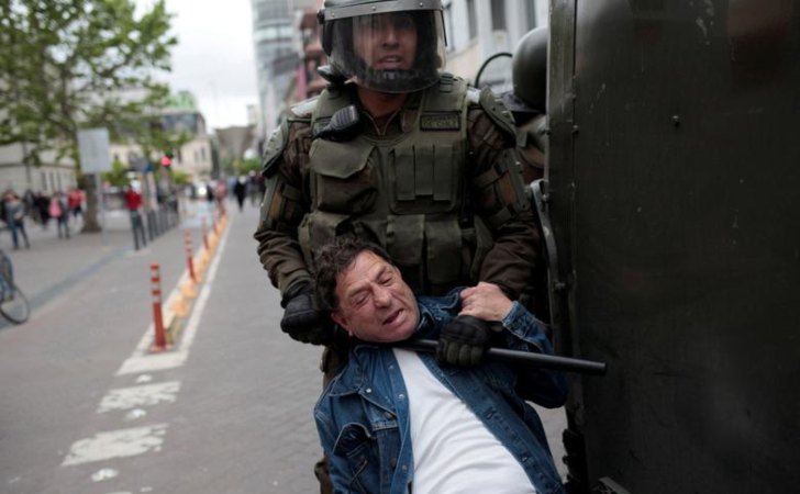 Manifestante es detenido por un carabinero en Chile / Foto: Reuters