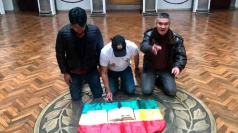 El líder opositor boliviano de extrema derecha, Luis Fernando Camacho, en el palacio presidencial de Bolivia con una Biblia sobre la bandera del país, después del golpe de Estado