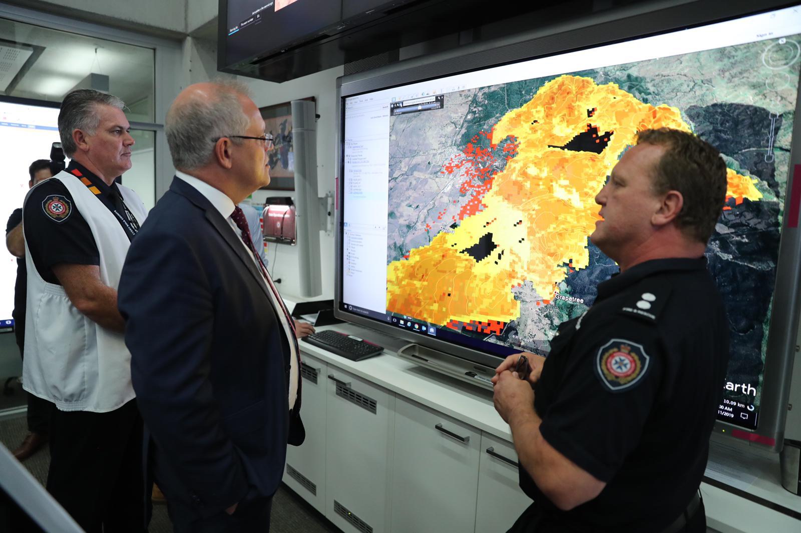Scott Morrison (centro) observa explicaciones de funcionarios de Servicio de bomberos rurales de Nueva Gales del Sur. Foto: Twitter / Scott Morrison