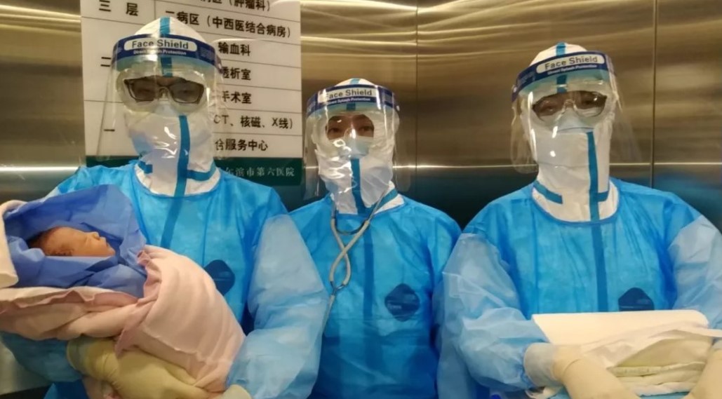 Médicos chinos sostienen a un bebé recién nacido: su madre estaba contagiada con coronavirus. Foto: Redes sociales