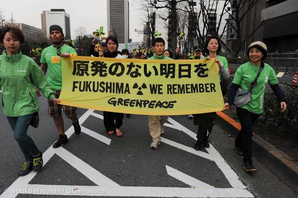 Manifestantes de Greenpeace portan un cartel en protesta al manejo del desastre de Fukushima por parte del Estado japonés. Foto: Greenpeace