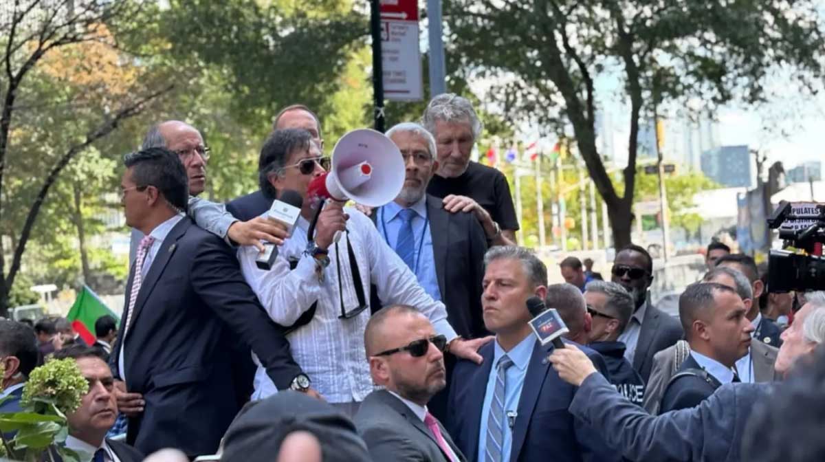 El presidente de Colombia sostiene un megafono para expresar sus palabras durante la manifestación.