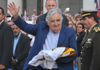 Mujica carga la bandera luego del arriado, en su última ceremonia de este tipo como Presidente. / Foto: Miguel Rojo - AFP