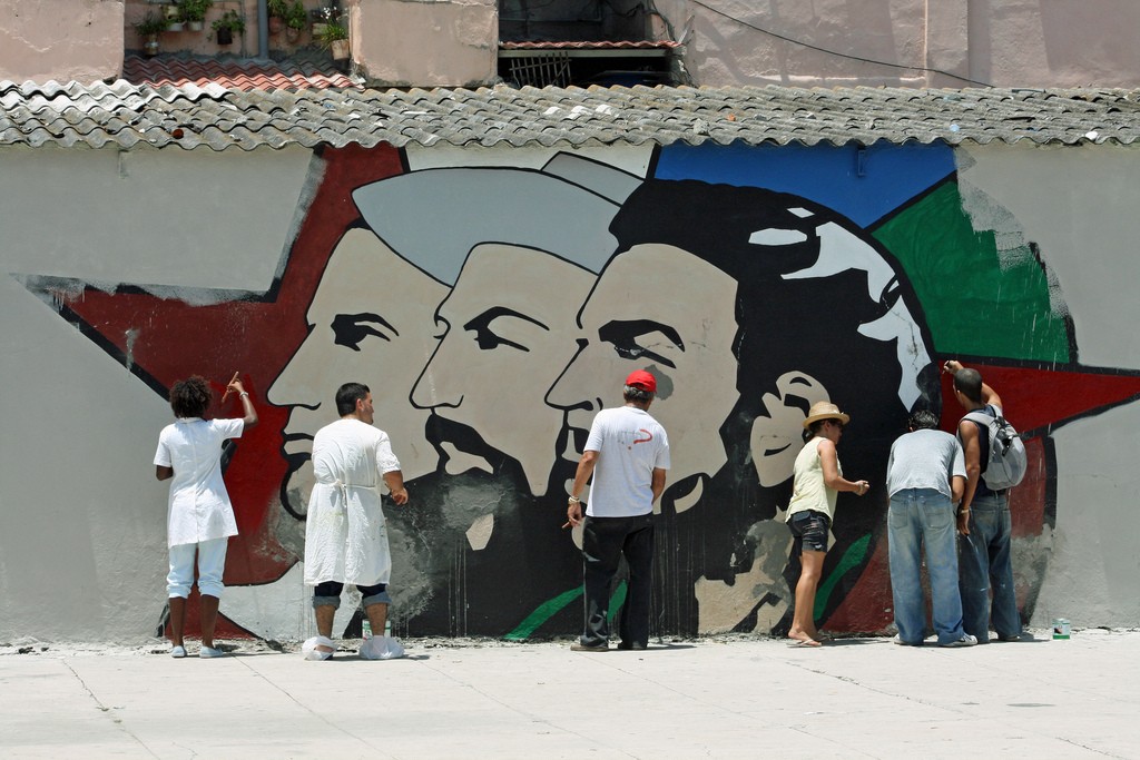 Voluntarios limpian y retocan un mural sobre la revolución cubana en La Habana. Foto: Carsten ten Brink.