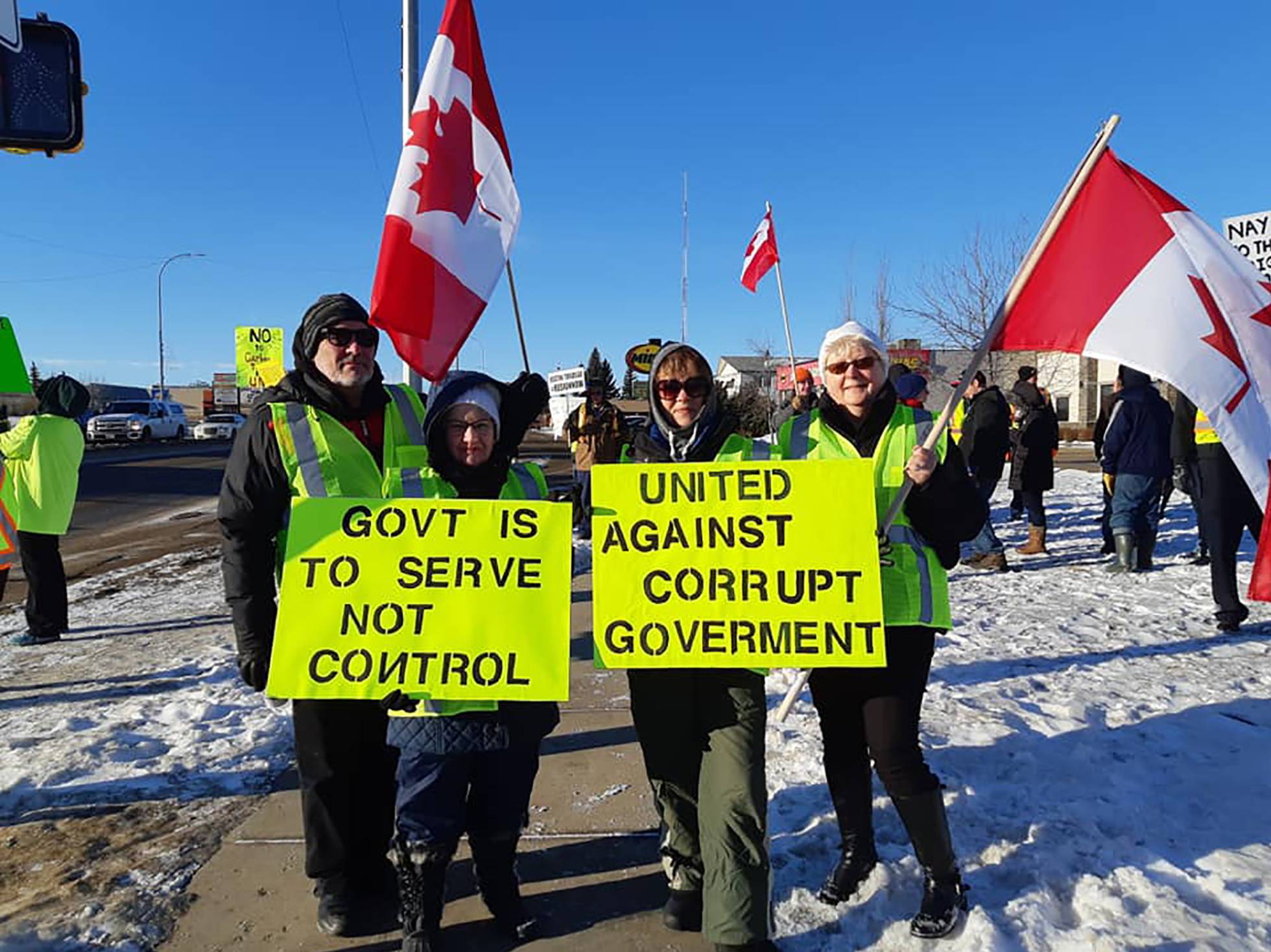 "El gobierno es para servir, no para controlar" y "Unidos contra el gobierno corrupto" son los rótulos que sostienen estos manifestantes. Foto: Facebook Yellow Vests Canada