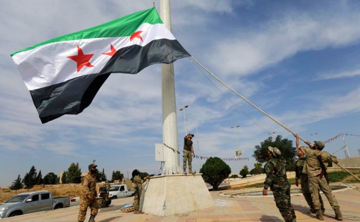 Rebeldes sirios apoyados por Turquía cuelgan la bandera de la Oposición siria / Foto: Reuters