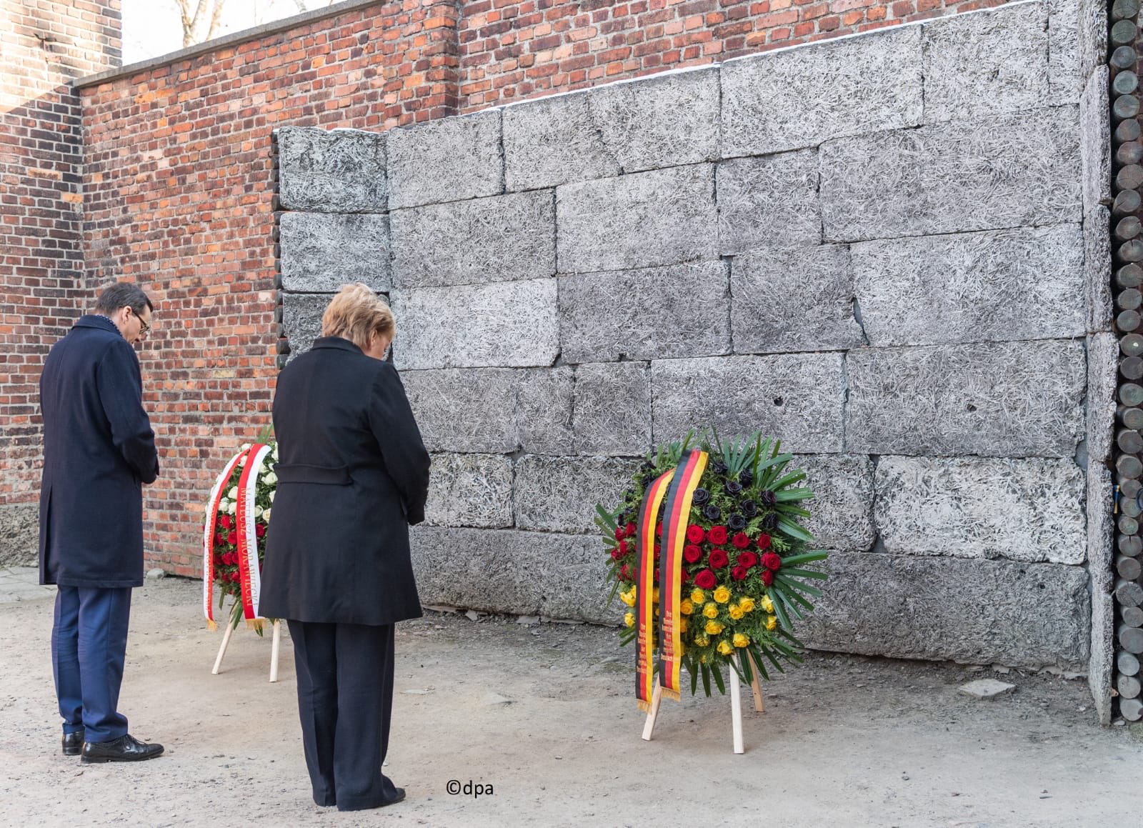 Merkel frente al Muro de la Muerte, lugar de fusilamiento en . Foto: Auschwitz Memorial / Rolf Nikel
