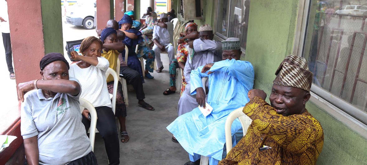 Vecinos de un pueblo de Lagos, Nigeria, aprenden cómo estordunar en el pliegue interno del brazo para prevenir la propagación del coronavirus. Foto: UNICEF