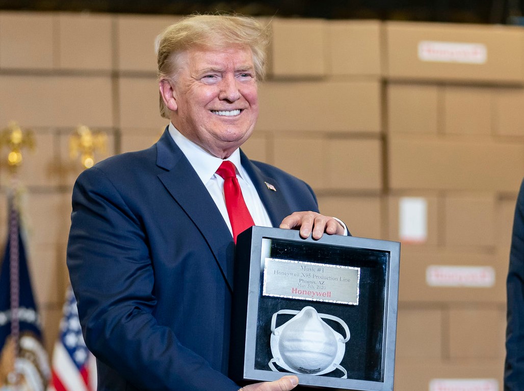 Trump sostiene una mascarilla de regalo que la empresa Honeywell le regaló en su visita a la planta de Arizona. Foto: The White House / Flickr