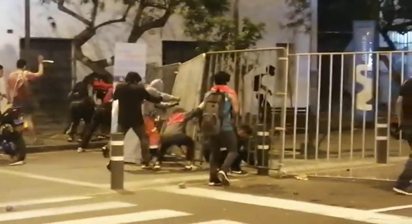 Un grupo de jóvenes tratan de derribar barricadas colocadas por la policía en Lima. Foto: Twitter / RPP