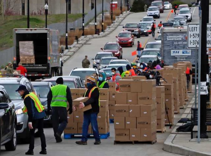 Decenas de voluntarios entregan cajas de alimentos a los miles de autos que se alinearon en Austin, Texas, el pasado 21 de noviembre. Foto: Twitter / Benjamin Riensche 