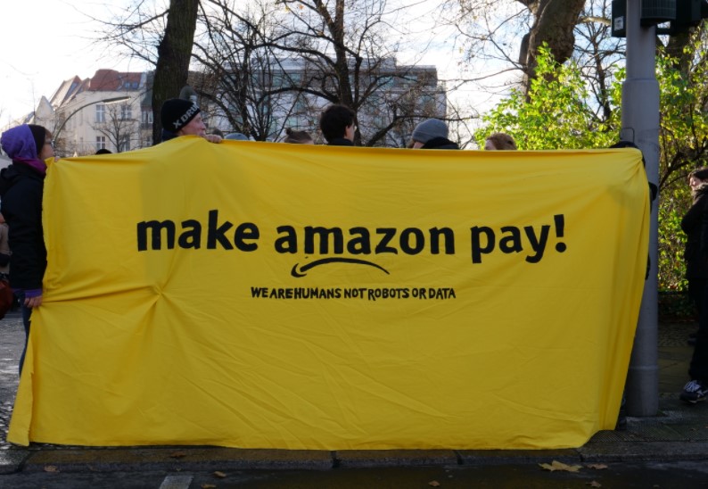 "Hagamos que Amazon pague. Somos humanos, no robot o datos", reza una pancarta en una manifestación de trabajadores de la compañía, hecha en 2017. Foto: Wikimedia Commons