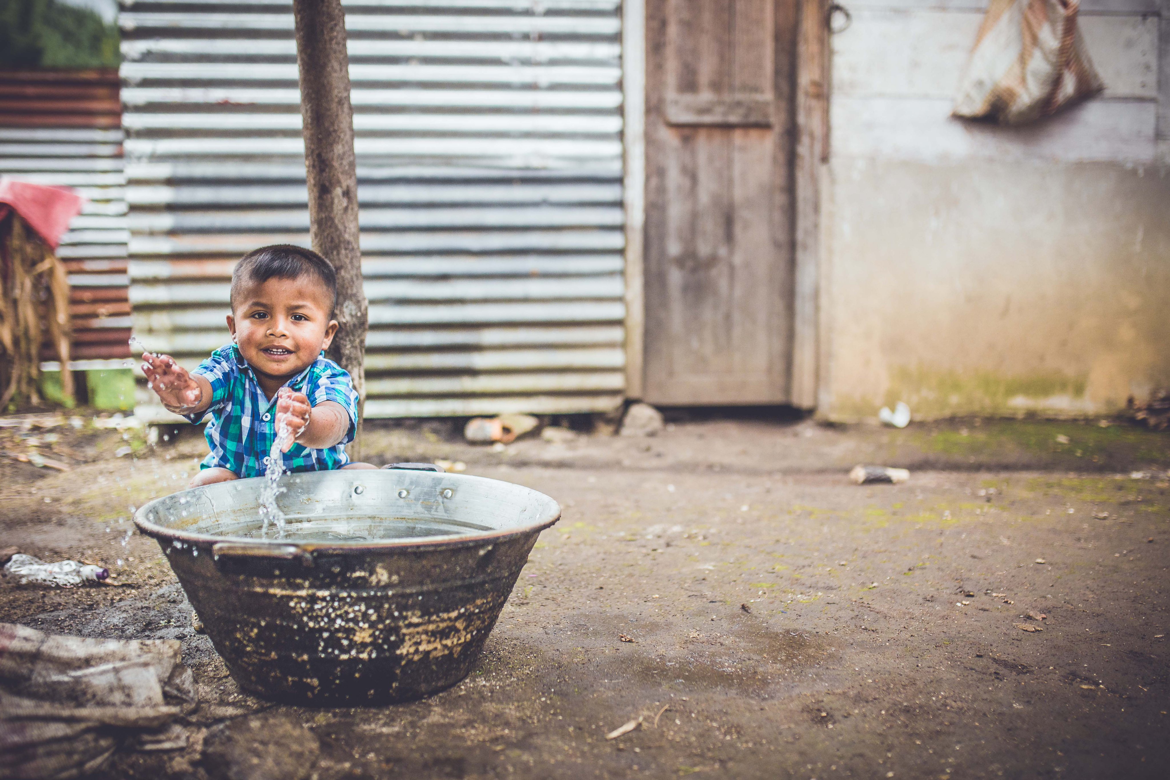 Marlon de 3 años se lava las manos antes de comer. Lo hace rápido y pronto la tarea se vuelve en juego y empieza a mojar a su perro. El agua potable es imprescindible para la la salud, el desarrollo, la seguridad y el futuro de cada niña y niño. Foto: UNICEF Guatemala