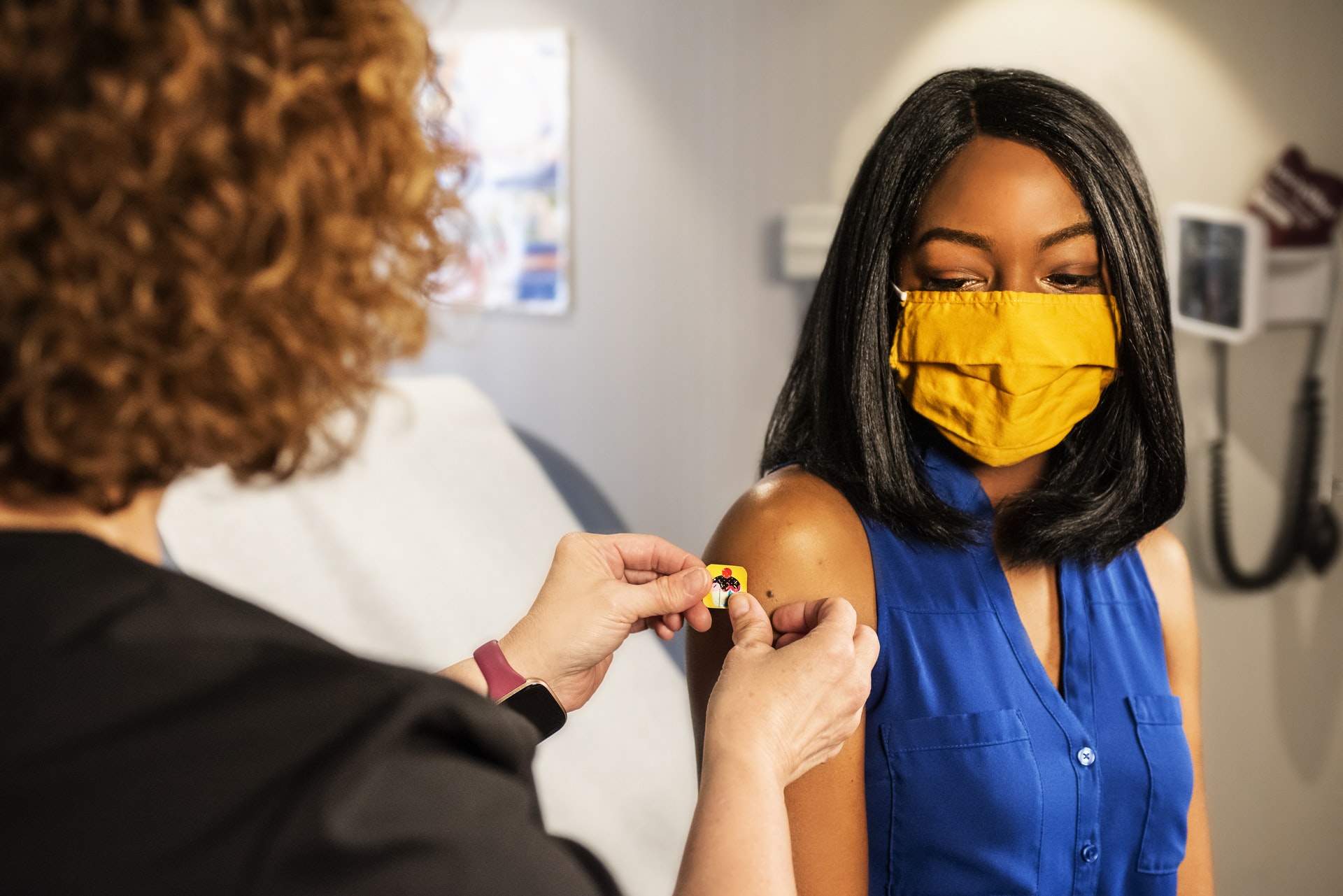 Una enfermera pone una bandita a una joven en su brazo, después de haber aplicado una vacuna. Foto: UNsplash / CDC