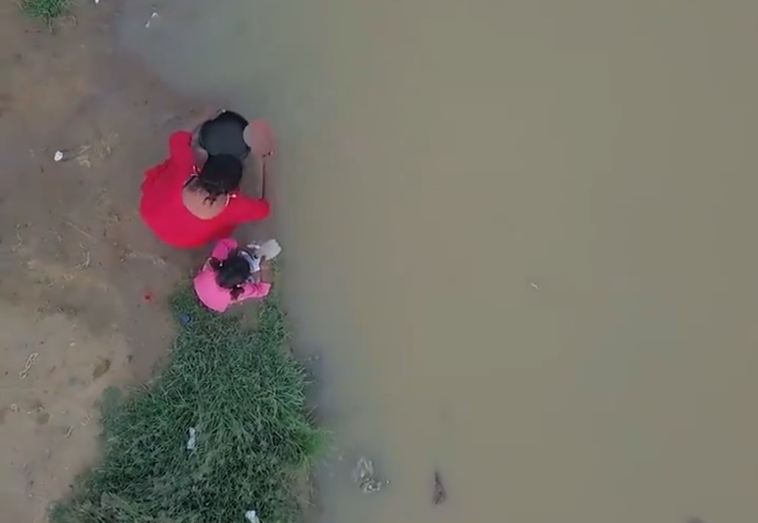 Una madre y su hija recogen agua de un cauce contaminado en Colombia. Foto: Twitter / UNICEF