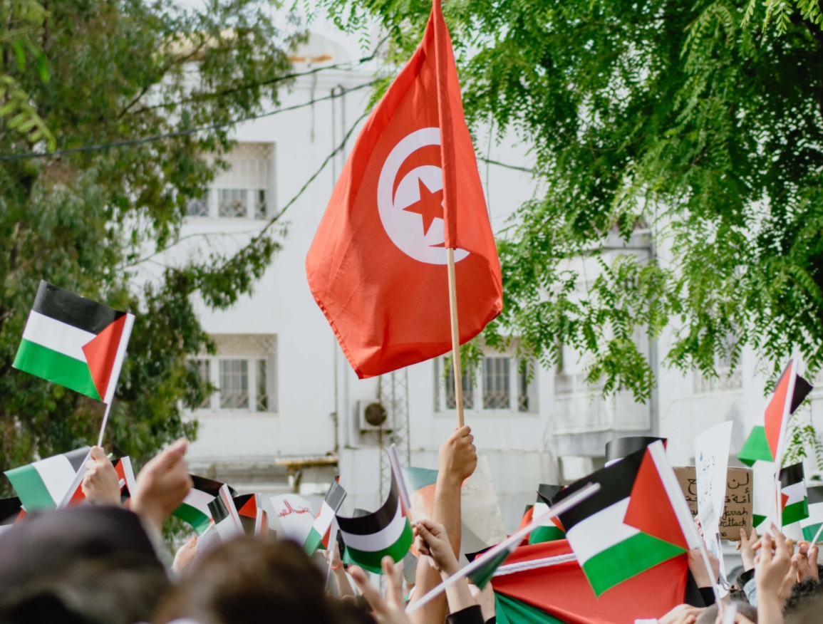 Una bandera de la República Tunecina ondea rodeada de otras de Palestina en una protesta en la capital Túnez en marzo de 2021. Foto: UNsplash / Latrach Med Jamil