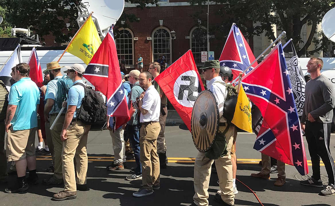 Miembros de la derecha alternativa se preparan para entrar en el Parque de la Emancipación en Charlottesville con banderas nazis, confederadas y de Gadsden de "No me pises". Foto: Wikimedia Commons