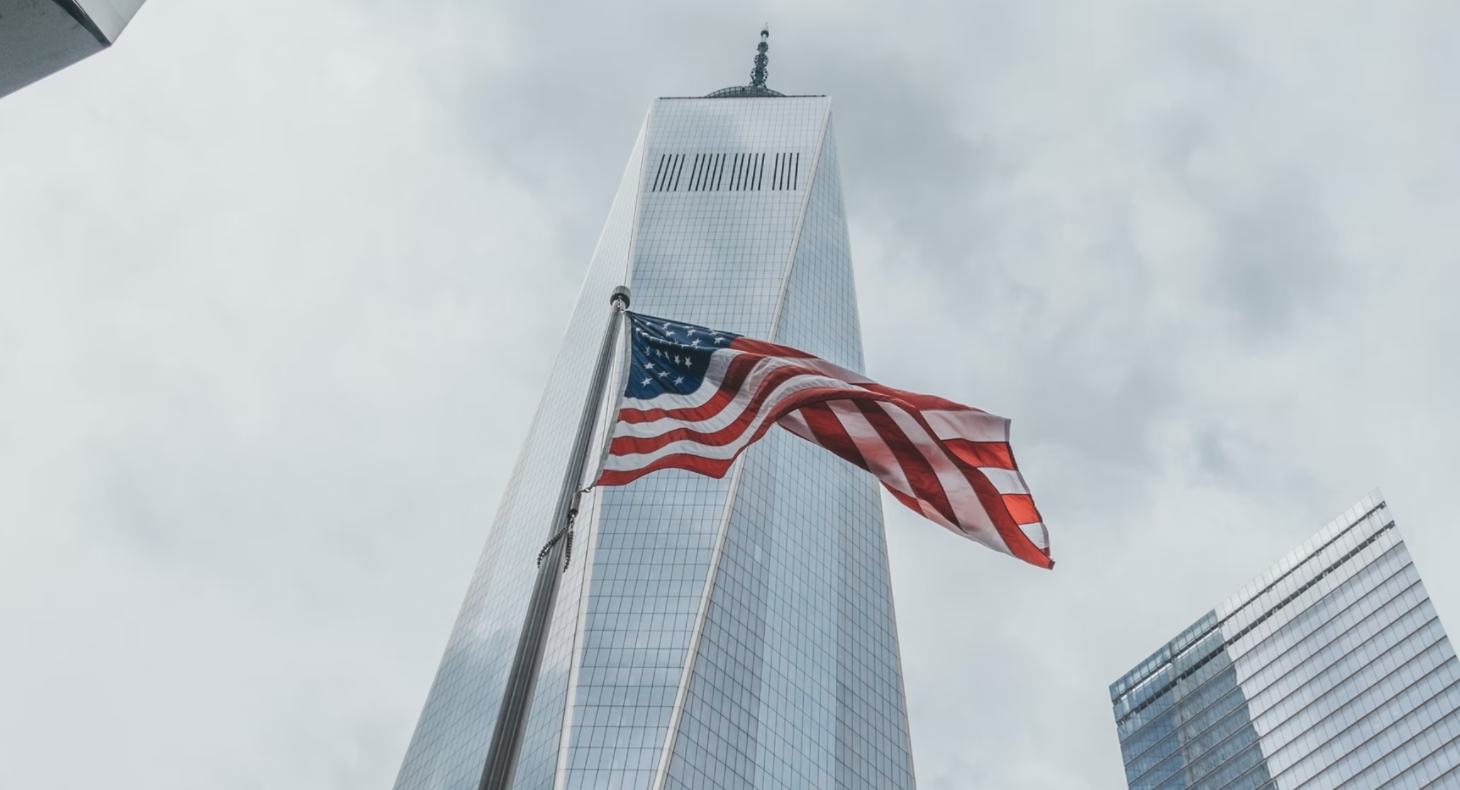 La bandera estadounidense ondea frente al One World Trade Center, en Nueva York, donde alguna vez estuvieron las Torres Gemelas. Foto: UNsplash / Lukas Zischke